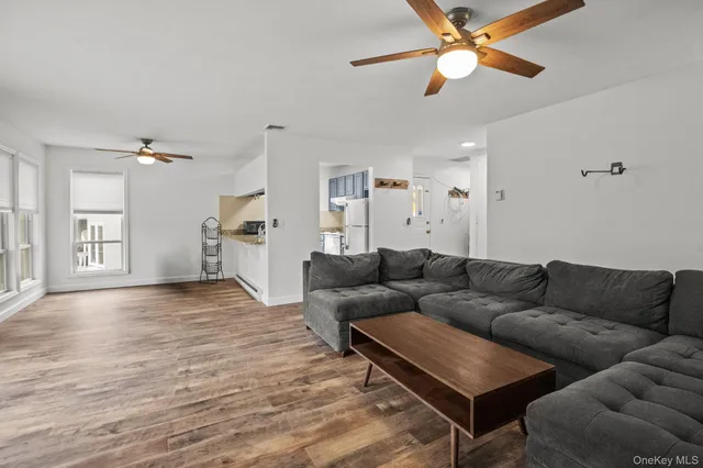 a living room with furniture and a ceiling fan