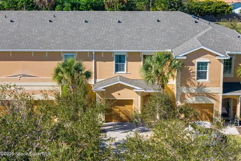 a aerial view of a house with a yard and large tree