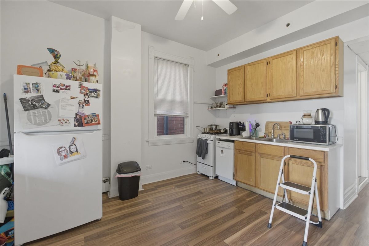 3507 North Seminary Avenue, Unit 2F Chicago, IL 60657 - Photo 2 of 10 a kitchen with stainless steel appliances granite countertop a refrigerator sink and wooden floor