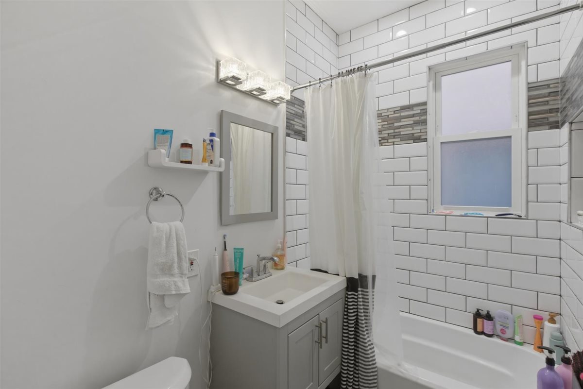 3507 North Seminary Avenue, Unit 2F Chicago, IL 60657 - Photo 10 of 10 a bathroom with a sink toilet vanity and shower