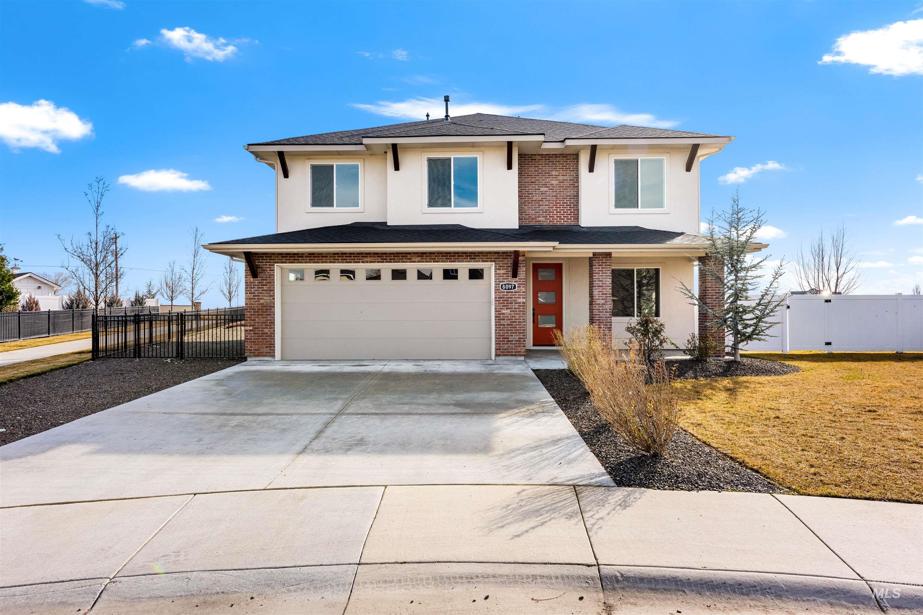 View of front of home with concrete driveway, an attached garage, stucco siding, brick siding, and a shingled roof