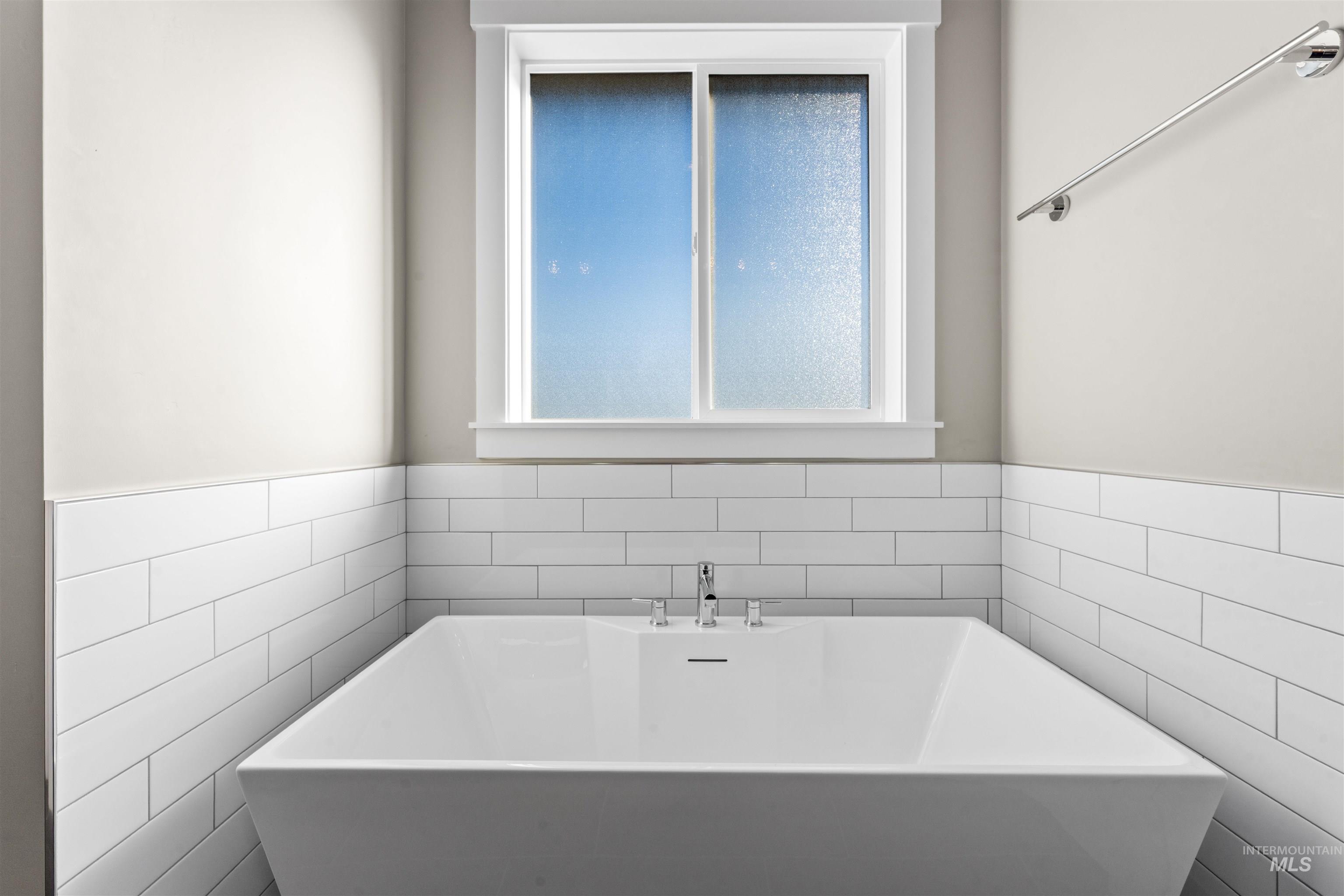 8097 Tandy Cove Street Middleton, ID 83644 - Photo 22 of 37 Full bath with a soaking tub, tile walls, and a wainscoted wall
