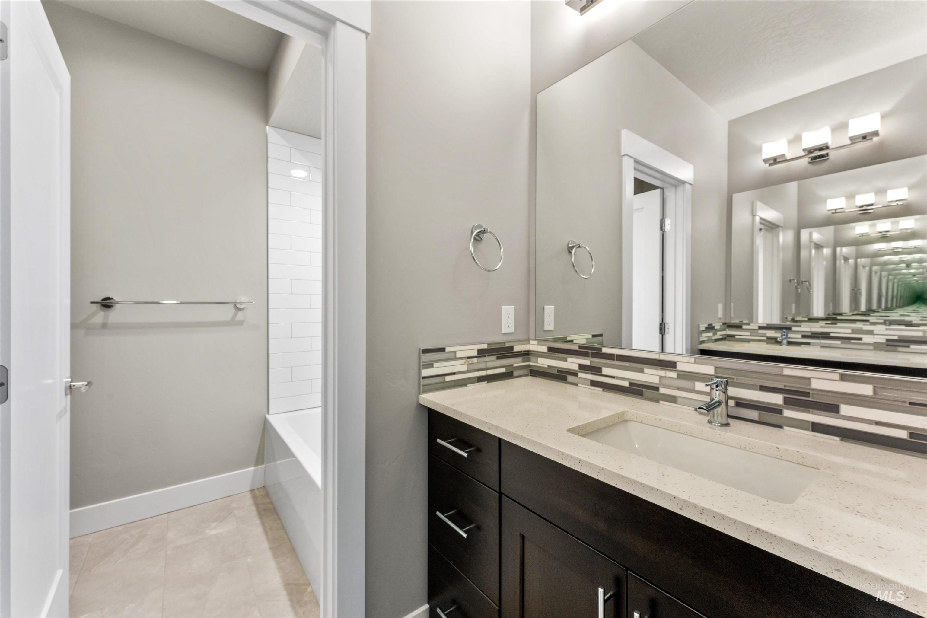 8097 Tandy Cove Street Middleton, ID 83644 - Photo 31 of 37 Full bath with vanity, washtub / shower combination, and light tile patterned floors