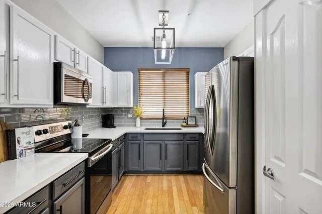 a kitchen with stainless steel appliances granite countertop a sink stove and refrigerator