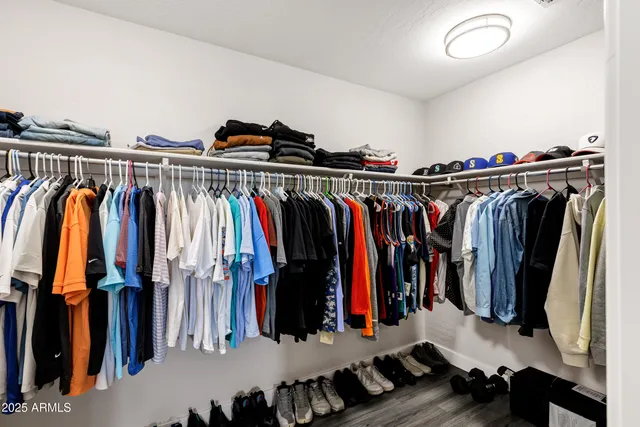 a view of walk in closet with clothes