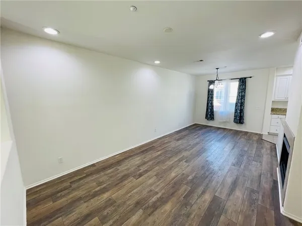 an empty room with a fireplace and wooden floor