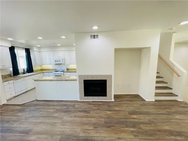 a view of kitchen with wooden floor and electronic appliances