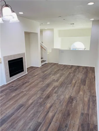a view of empty room with wooden floor and fireplace