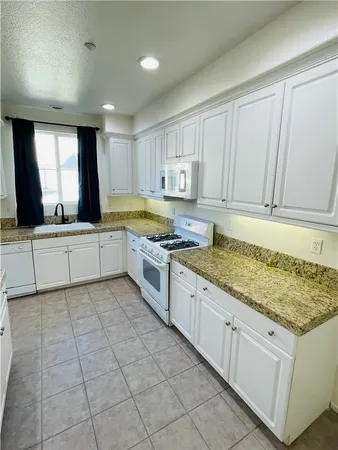 a kitchen with a sink window and cabinets