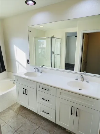a bathroom with a double vanity sink mirror and bathtub