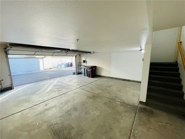 a view of empty room with stairs and fan