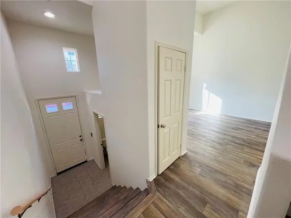 a view of a hallway with wooden floor and entryway