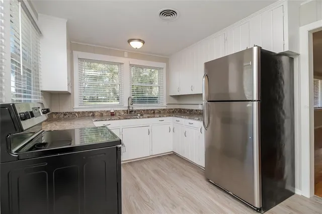 a kitchen with a refrigerator sink and cabinets
