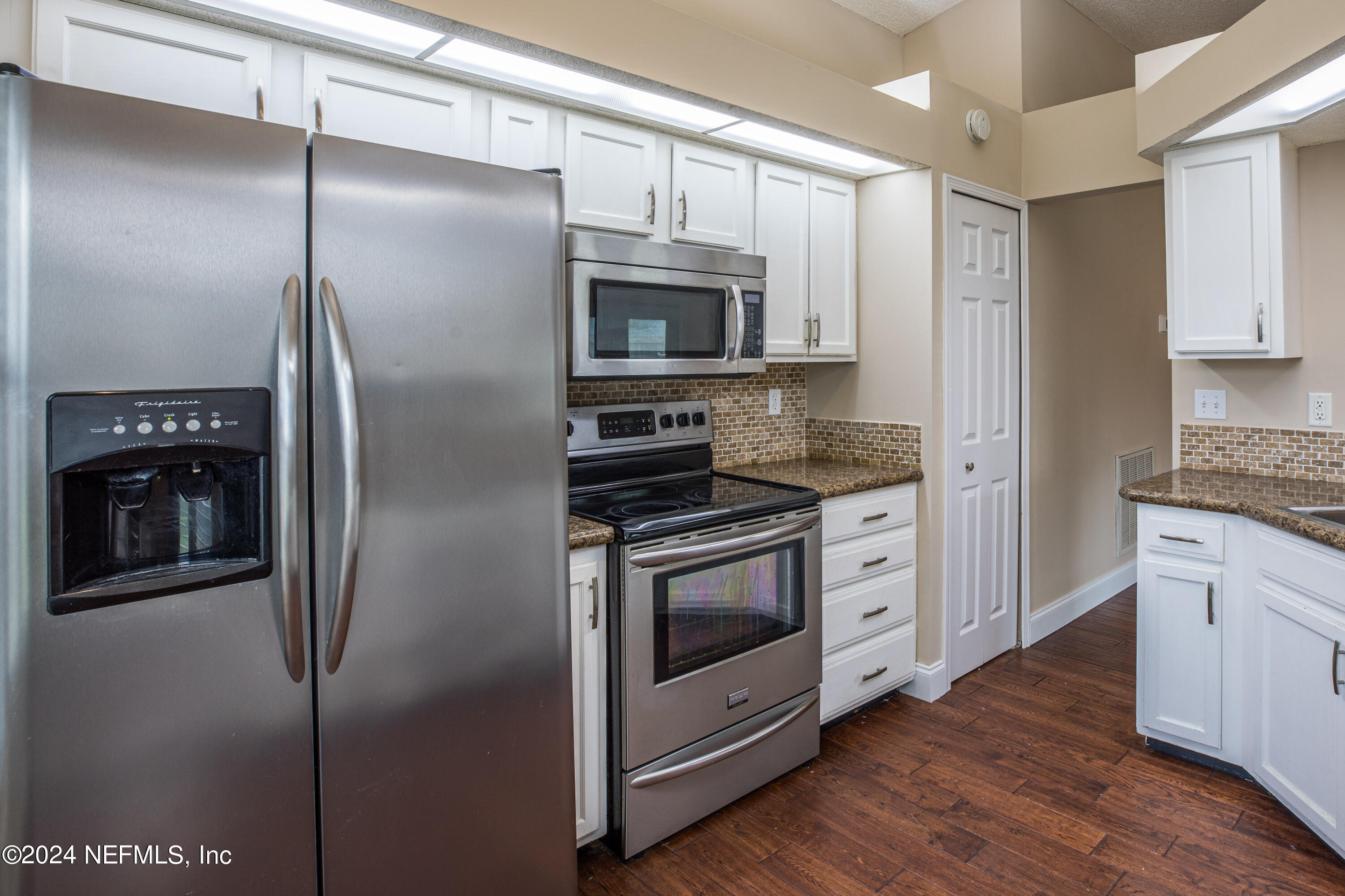 8691 Hammond Forest Drive Jacksonville, FL 32221 - Photo 14 of 28 a kitchen with stainless steel appliances and wooden floor