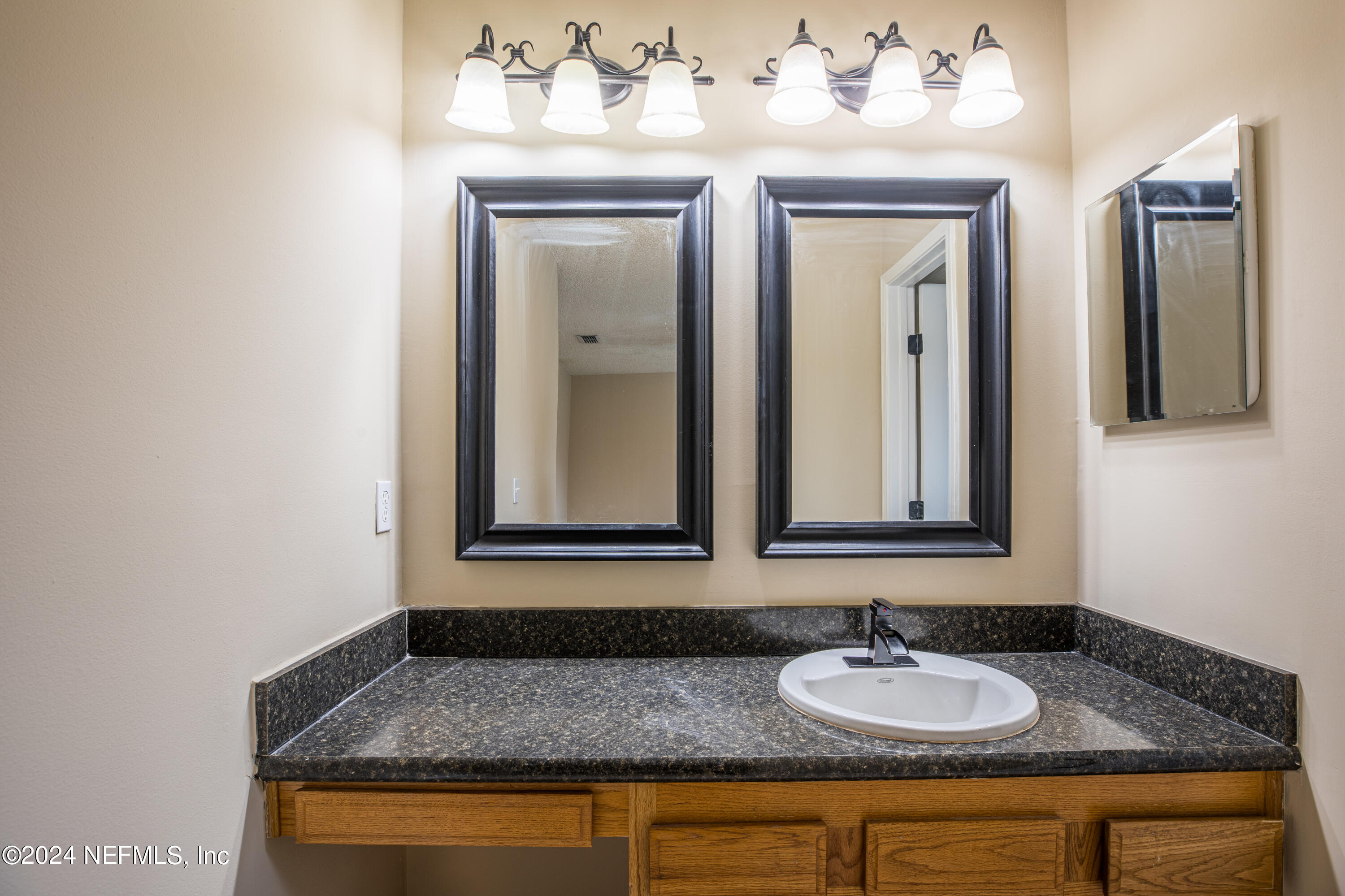 8691 Hammond Forest Drive Jacksonville, FL 32221 - Photo 20 of 28 a bathroom with a granite countertop sink and a mirror