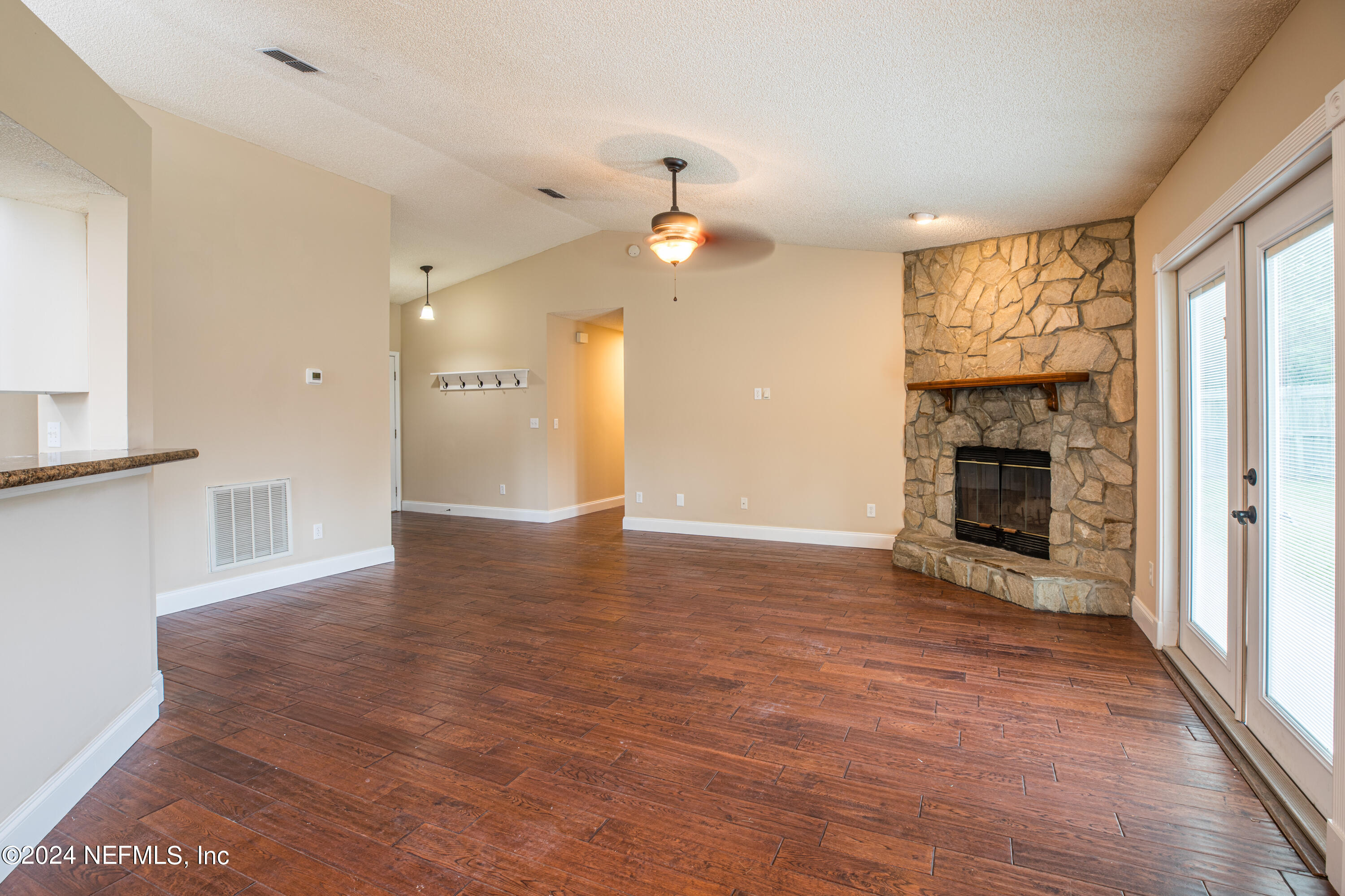 8691 Hammond Forest Drive Jacksonville, FL 32221 - Photo 10 of 28 an empty room with wooden floor fireplace and windows
