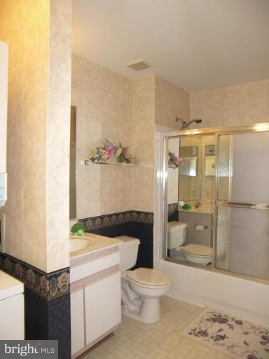 673 Constellation Square Southeast, Unit J Leesburg, VA 20175 - Photo 19 of 25 a bathroom with a granite countertop sink a toilet and shower