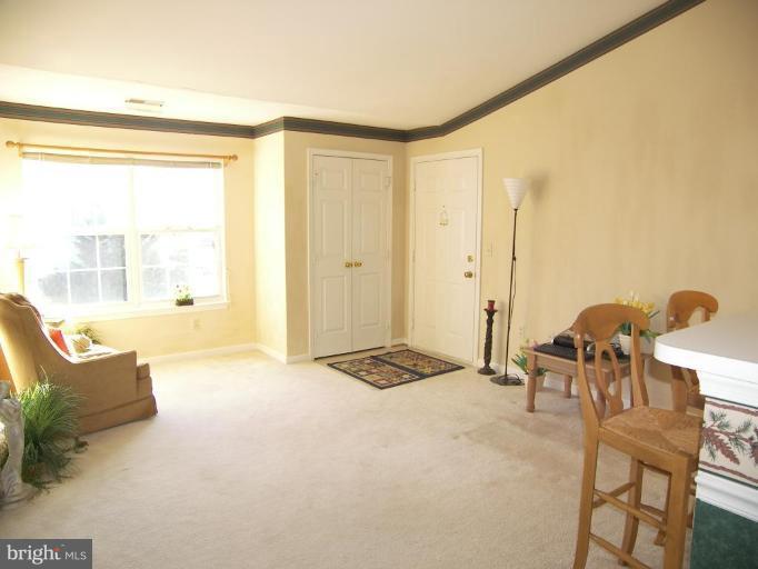 673 Constellation Square Southeast, Unit J Leesburg, VA 20175 - Photo 3 of 25 a living room with furniture and a large window