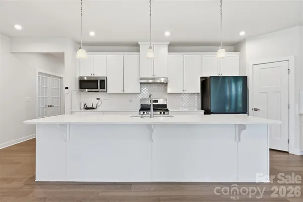 a kitchen with kitchen island a counter top space stainless steel appliances and cabinets