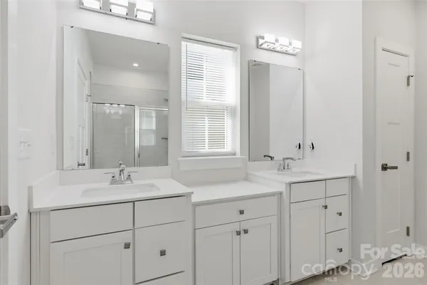 a bathroom with double sink and a mirror