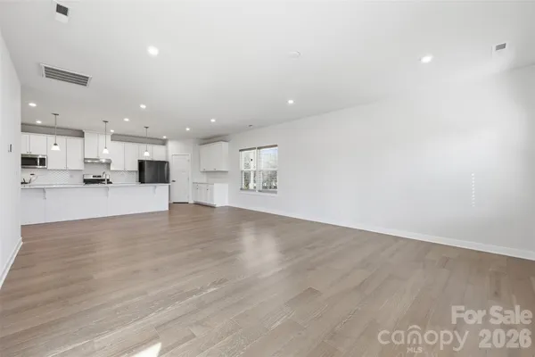a view of kitchen with kitchen island white cabinets and wooden floor