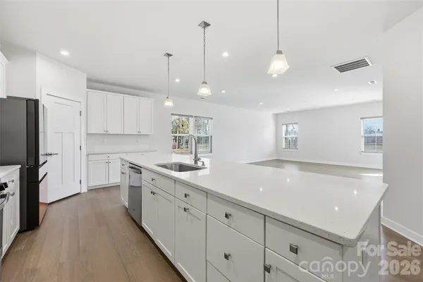 a kitchen with a sink center island a refrigerator and cabinets