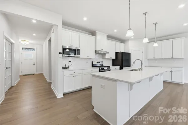 a kitchen with white cabinets sink and stainless steel appliances