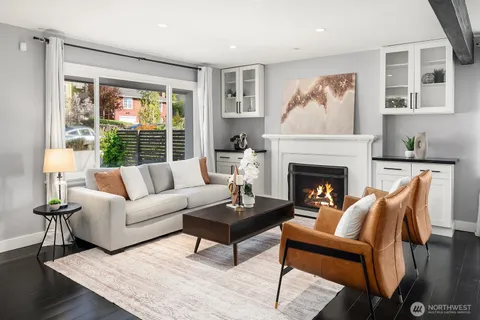 a living room with furniture a large window and a fireplace