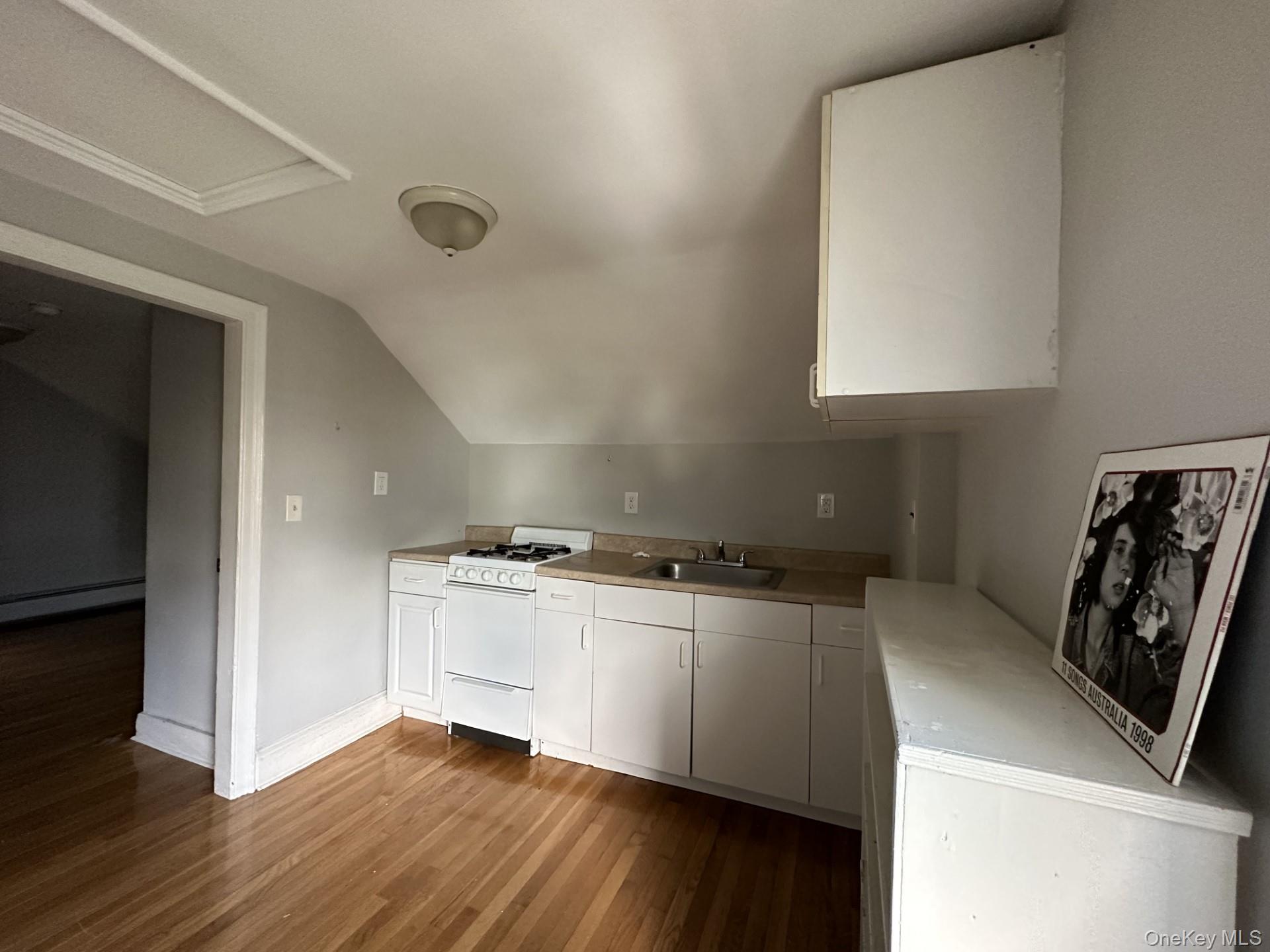 10 Prospect Street Nyack, NY 10960 - Photo 2 of 7 Kitchen featuring white cabinets, gas range gas stove, light countertops, light wood-style floors, and vaulted ceiling