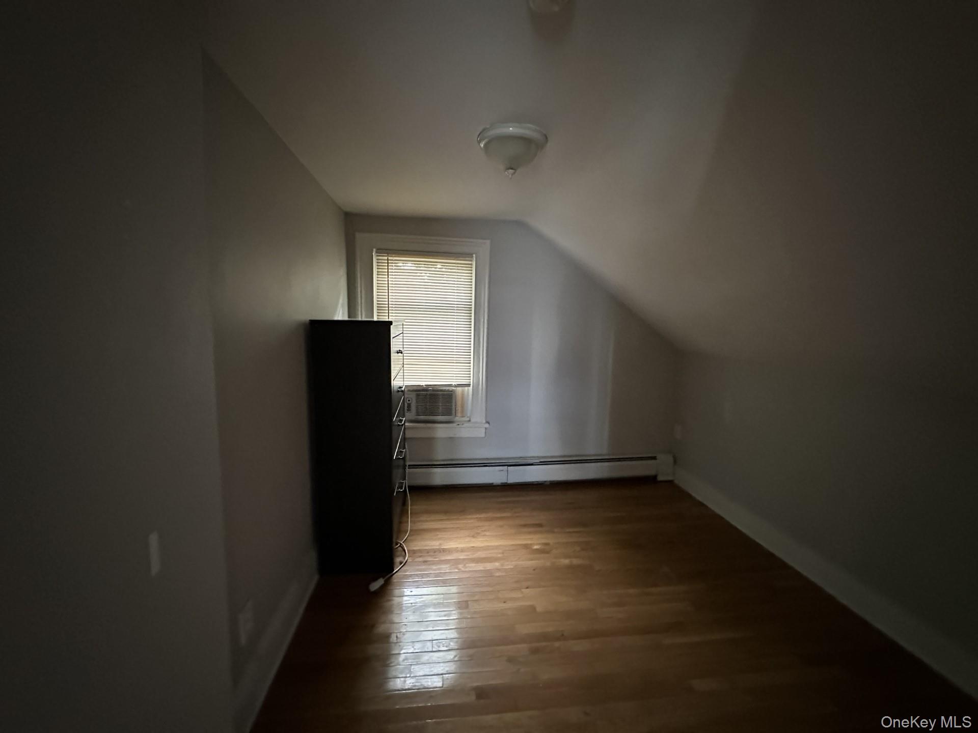 10 Prospect Street Nyack, NY 10960 - Photo 3 of 7 Additional living space featuring lofted ceiling, a baseboard heating unit, and dark wood-style flooring