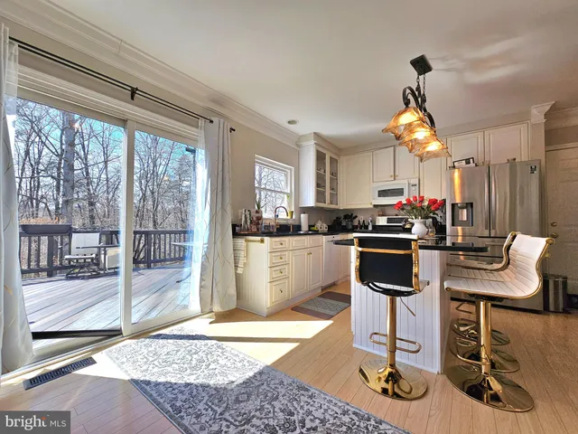 a kitchen with a stove a refrigerator and wooden floor