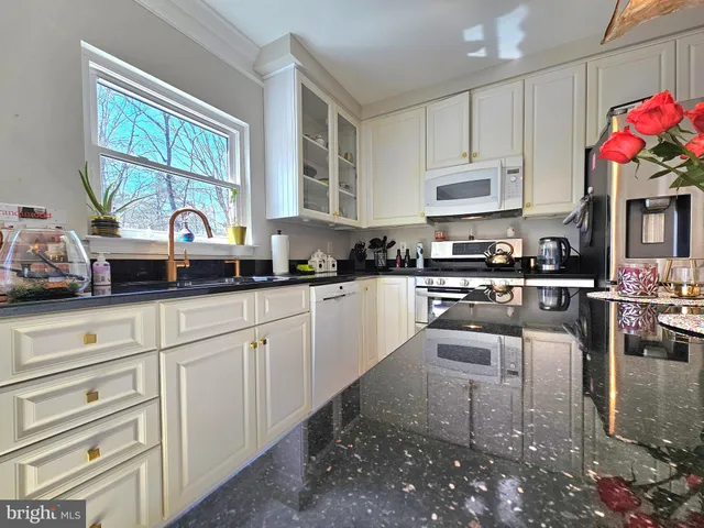 a kitchen with kitchen island granite countertop a white cabinets and window
