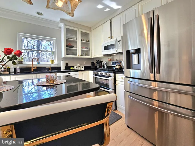 a kitchen with stainless steel appliances white cabinets and a refrigerator