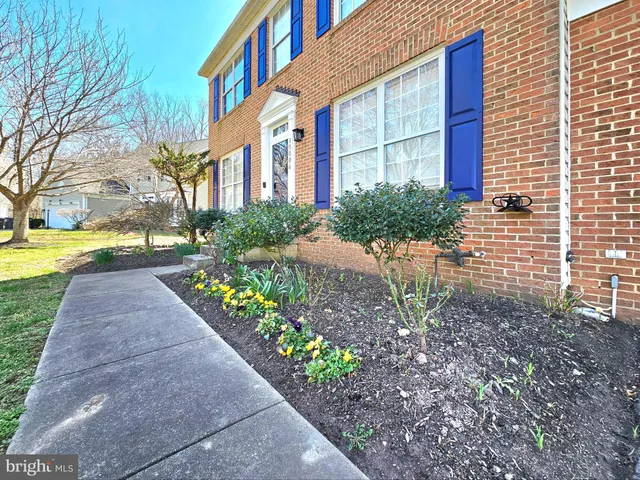 a view of a brick house with a yard and plants