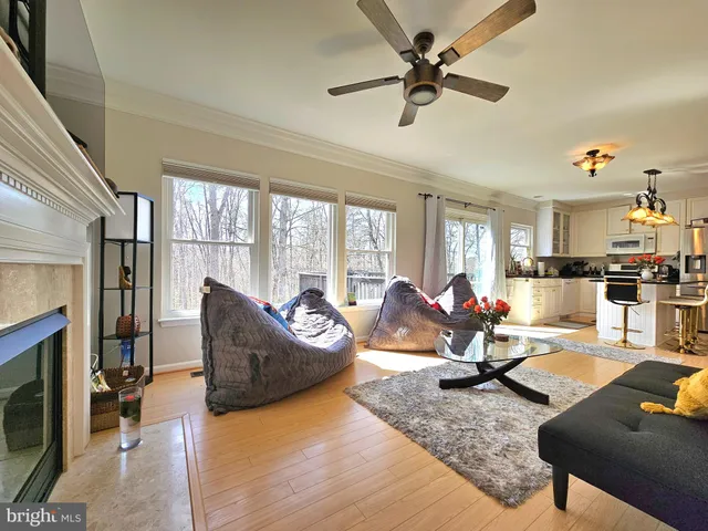 a living room with furniture fireplace and a large window