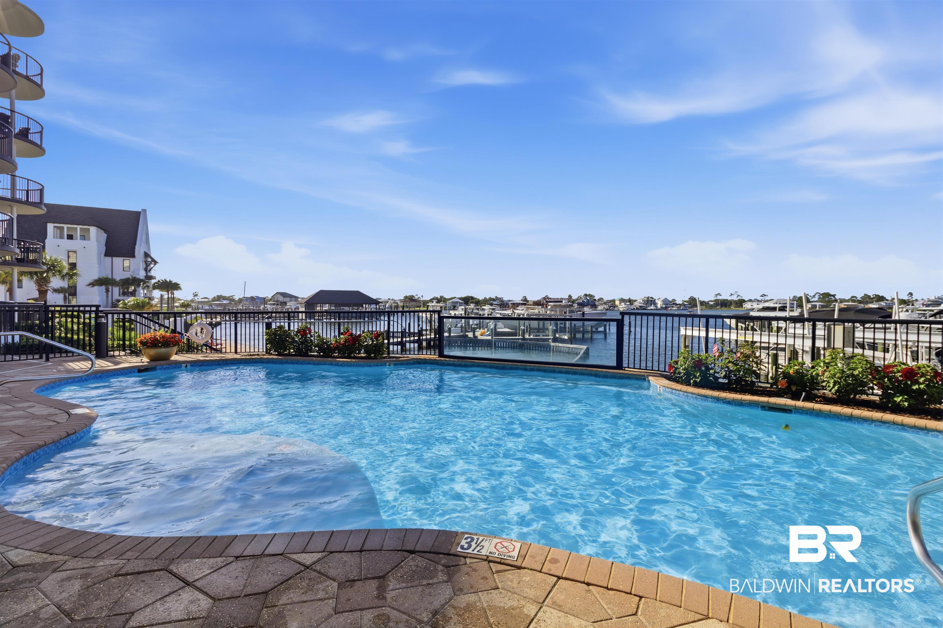 3564 Bayou Road, Unit 203 Orange Beach, AL 36561 - Photo 36 of 53 Inviting swimming pool with stone paver surround and waterfront setting