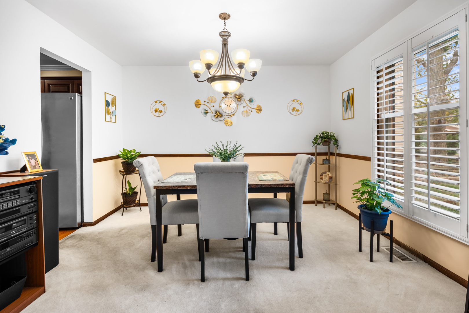3479 Ronald Road Crete, IL 60417 - Photo 7 of 38 a dining room with furniture potted plants and a chandelier