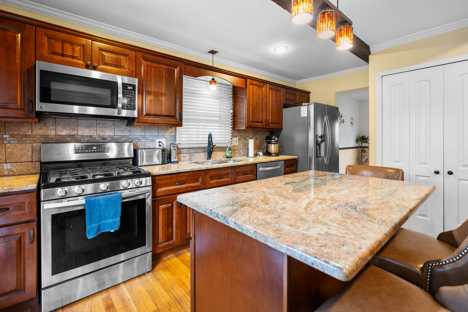 3479 Ronald Road Crete, IL 60417 - Photo 10 of 38 a kitchen with stainless steel appliances granite countertop a stove top oven a sink dishwasher and a microwave oven with large wooden cabinets