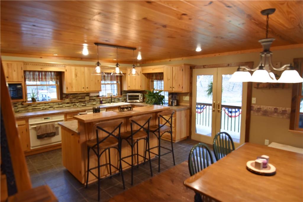1242 Stitts Run Road Vandergrift, PA 15690 - Photo 5 of 23 a kitchen with stainless steel appliances granite countertop a stove a sink dishwasher a dining table and chairs with wooden floor