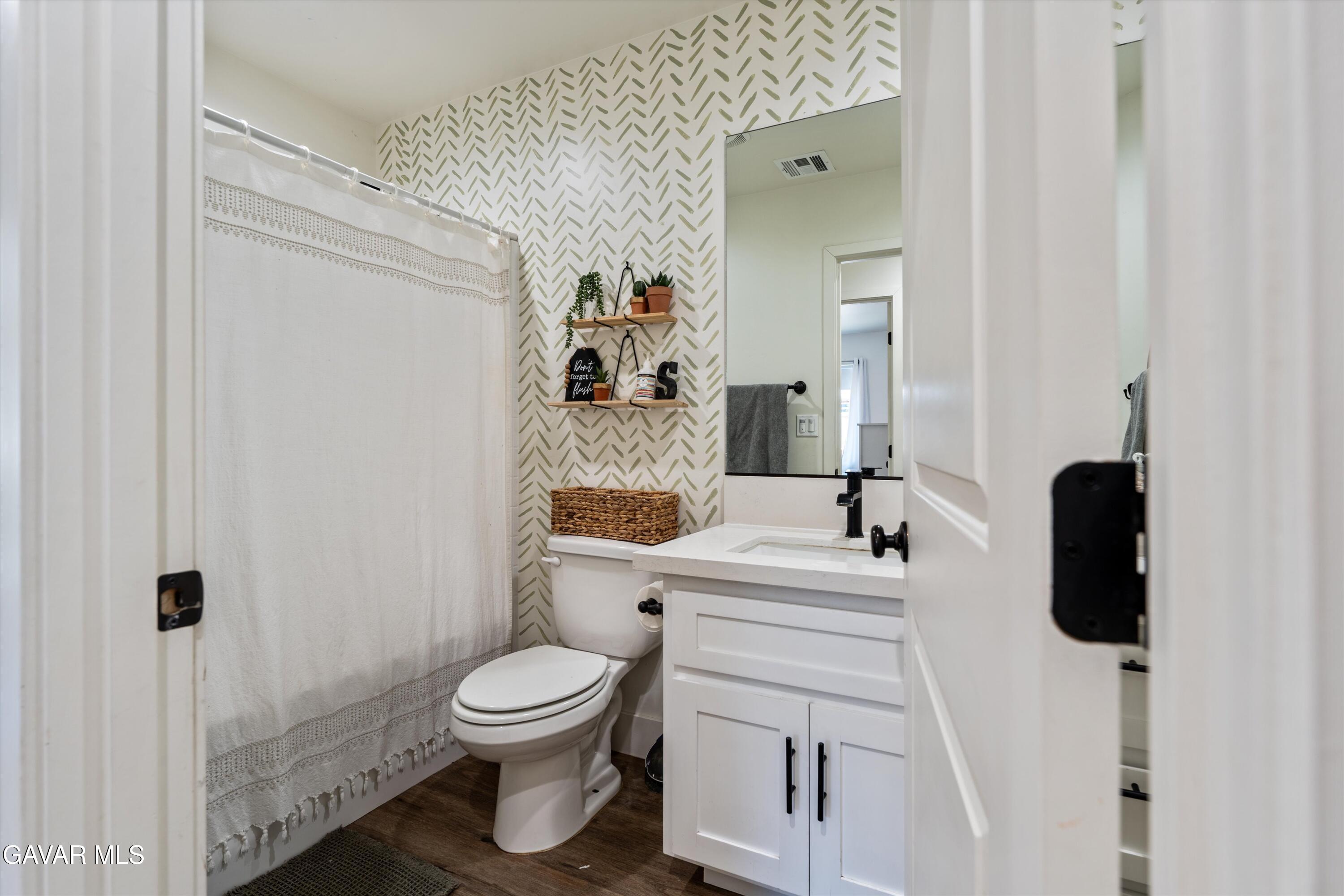 28060 Preakness Drive Tehachapi, CA 93561 - Photo 11 of 26 a bathroom with a toilet sink a mirror a vanity and shower