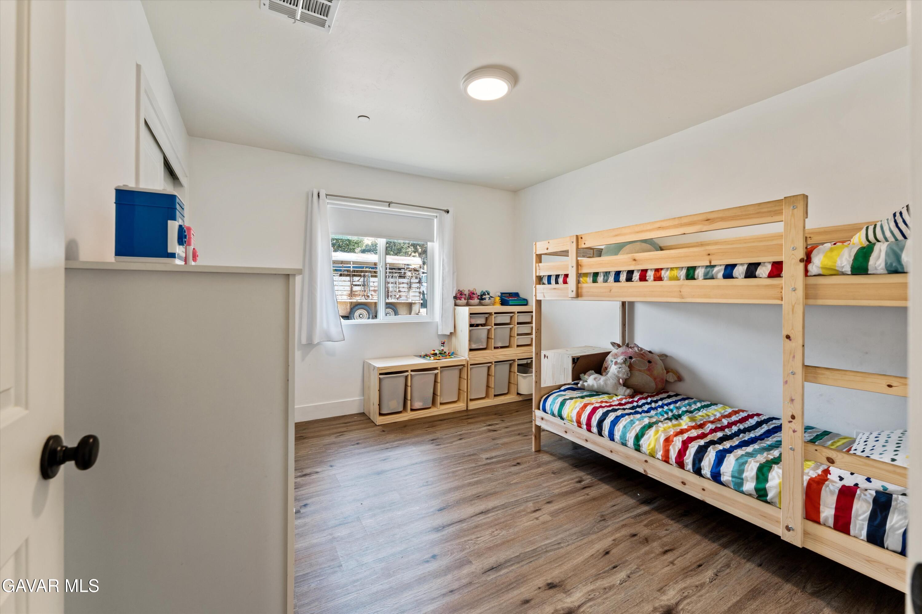 28060 Preakness Drive Tehachapi, CA 93561 - Photo 12 of 26 a bedroom with furniture and a book shelf