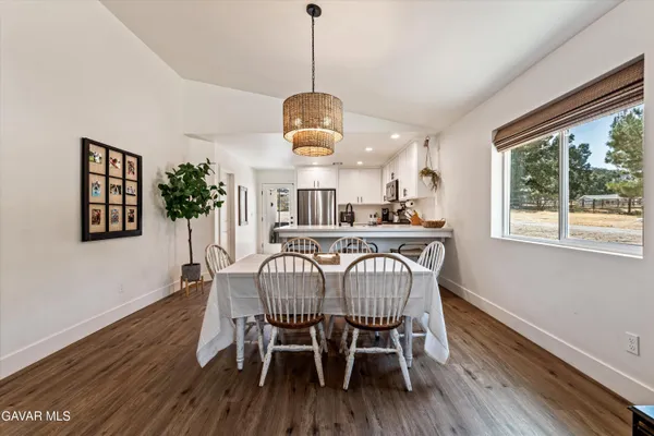 a dining room filled chandelier and wooden floor