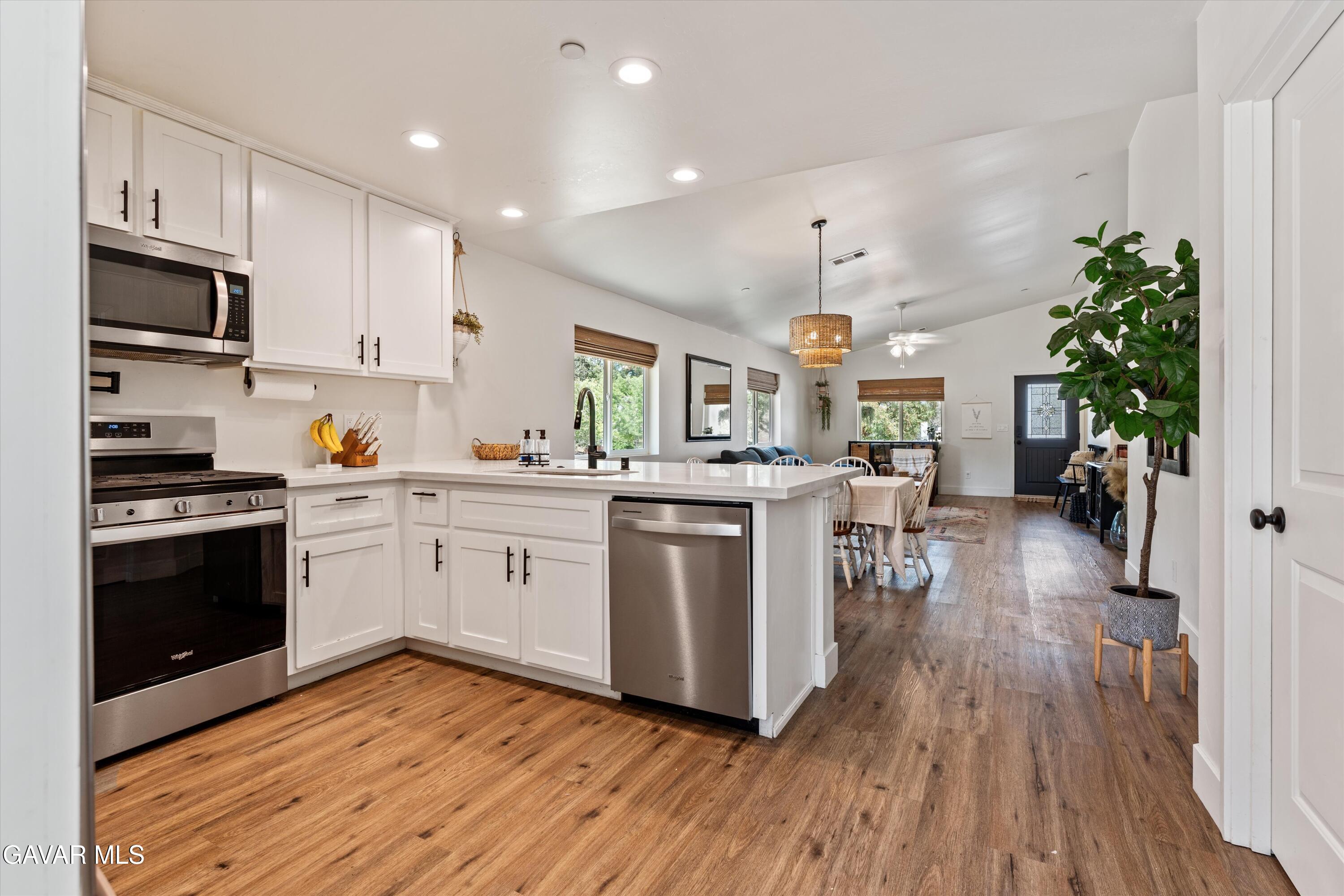 28060 Preakness Drive Tehachapi, CA 93561 - Photo 7 of 26 a kitchen with granite countertop a refrigerator stove and wooden floor