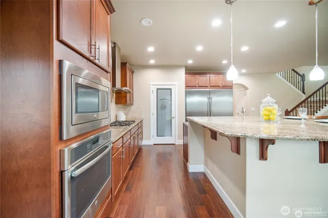 a kitchen with counter top space stainless steel appliances and wooden floor