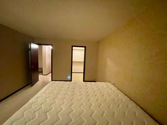 a bedroom with a bed and a dresser with mirror