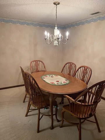 a view of a dining room with furniture and chandelier