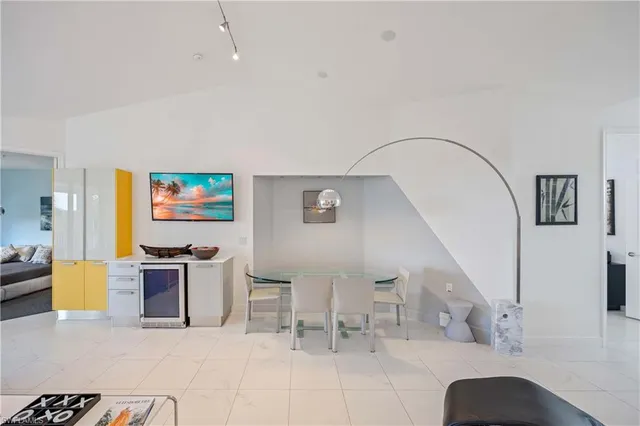 a living room with furniture a flat screen tv and wall paintings