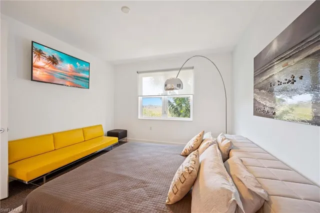 a bed sitting in a bedroom next to a window