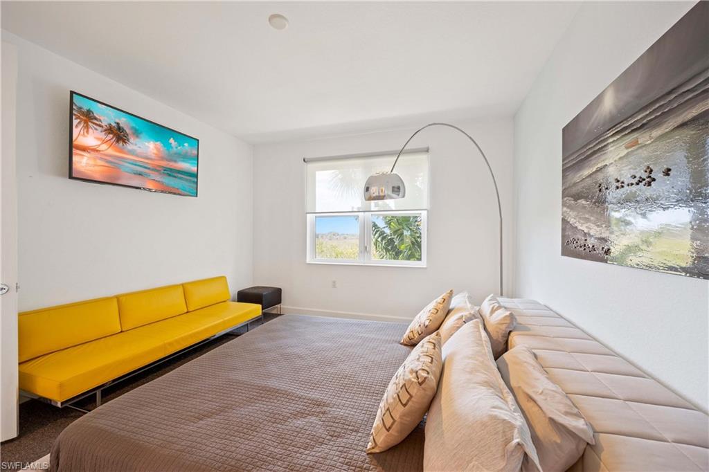 4685 Hawks Nest Way, Unit J201 Naples, FL 34114 - Photo 14 of 24 a bed sitting in a bedroom next to a window