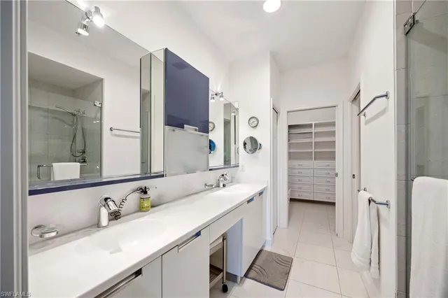 a bathroom with a double vanity sink a mirror and a bathtub